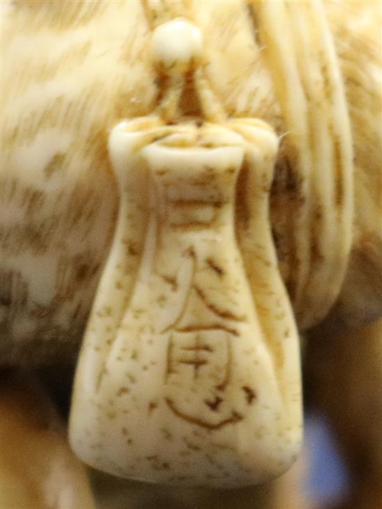 A Japanese ivory netsuke of an oni leaning on a cooking cauldron for rice, signed Tomomasa, 19th century, 4cm, loss to one toe